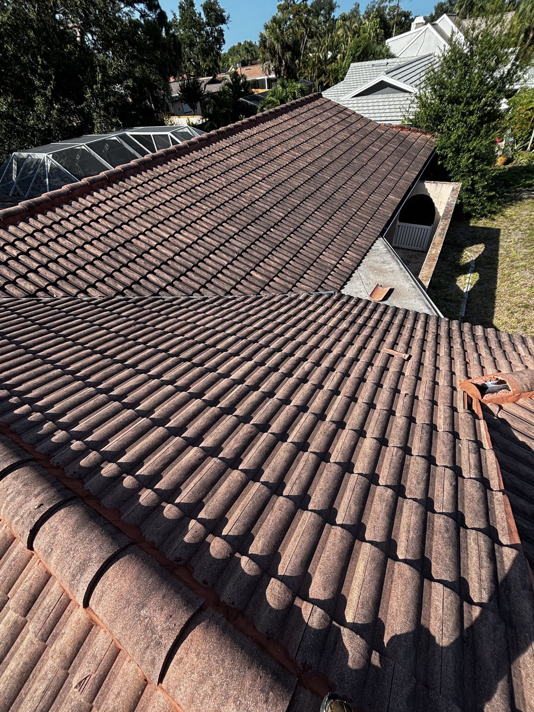Terracotta barrel-tile roof darkened with algae before cleaning