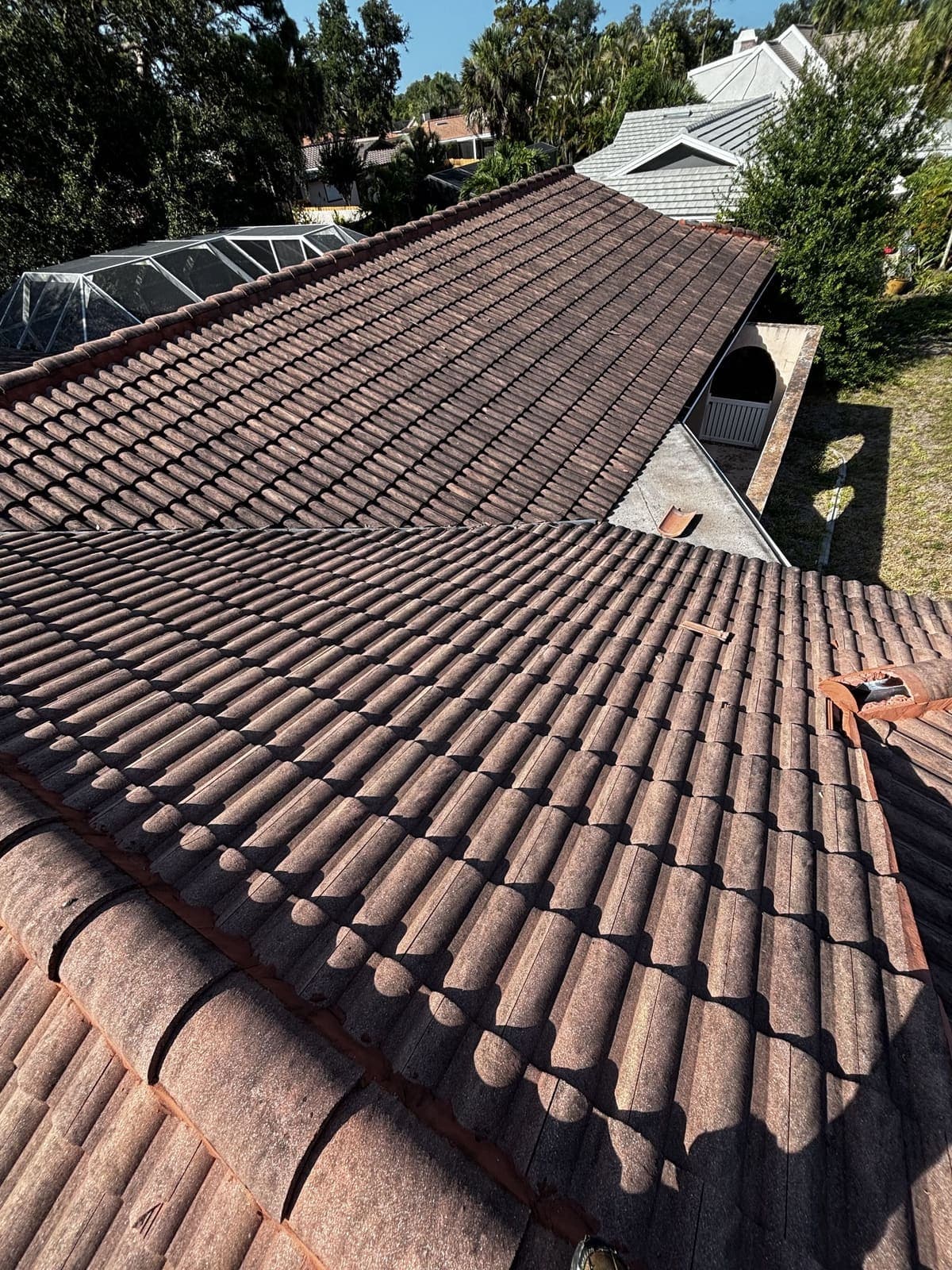 Terracotta barrel-tile roof darkened with algae before cleaning